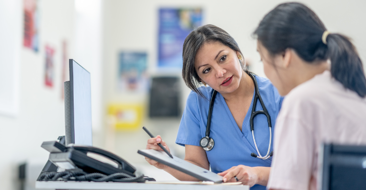 Doctor with stethoscope and clipboard talking to patient